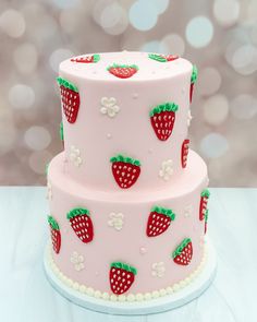 a three layer cake decorated with strawberries and flowers