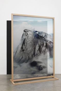 an art piece is displayed in front of a black and white background with the image of a mountain