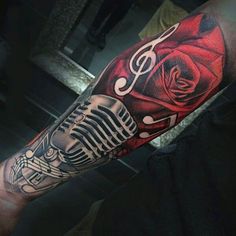 a man's arm with a microphone and rose tattoo design on the left forearm