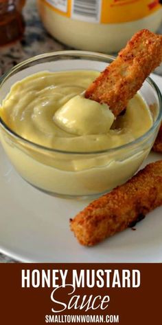 honey mustard sauce in a glass bowl with two fried fish sticks sticking out of it