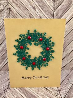 a christmas card with an ornament made out of green felt and red balls