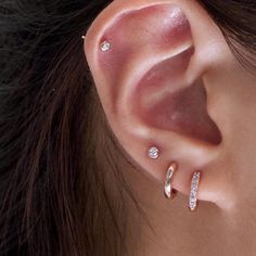 a close up of a person's ear with two different types of piercings