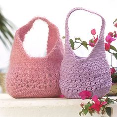 two crocheted purses sitting next to each other