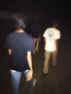 blurry photograph of people walking in the dark