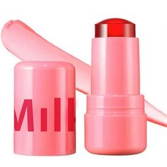 a pink lipstick with the word milk on it's side and an empty tube next to it