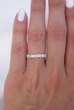 a woman's hand with a wedding band on it, and the ring is in white gold