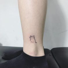 a small cat tattoo on the ankle