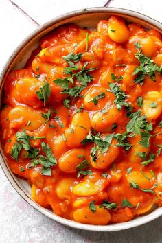 a bowl filled with tomato sauce and garnished with parsley