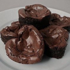 four chocolate cupcakes on a white plate