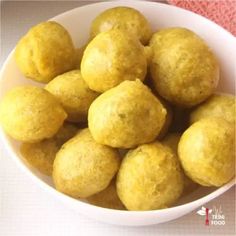 a white bowl filled with yellow food on top of a table