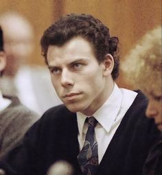 a man in a suit and tie sitting at a table