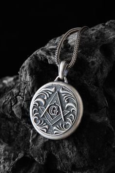 While there are many symbols associated with Freemasonry, none are more universally recognizable than the square and compasses. It is well-known enough that even those who are not personally acquainted with the fraternity understand the connection when they come across it. Like many aspects of Freemasonry, the precise origins of this symbol are unknown.  Made from high-quality 925 sterling silver for durability and long-lasting wear Features the iconic Masonic symbol, which is rich in symbolism Silver Jewelry With Engraved Logo, Silver Round Jewelry With Engraved Logo, Classic Etched Necklace For Collectors, Silver Jewelry With Engraved Logo For Gift, Symbolic Stamped Medallion Jewelry, Symbolic Square Pendant Necklace With Engraving, Masonic Symbol, The Letter G, Masonic Lodge