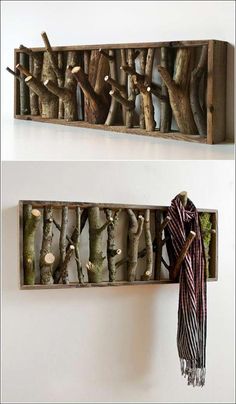 there are two wooden boxes with branches in them and one has a scarf hanging on the wall