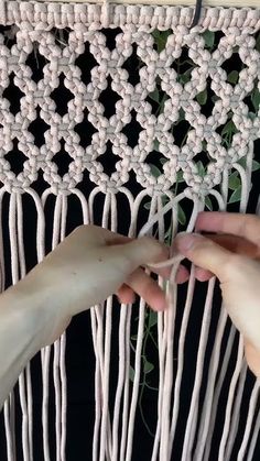 two hands are working on a weaving project