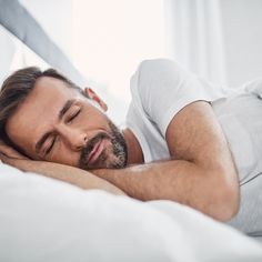 a man laying in bed with his eyes closed