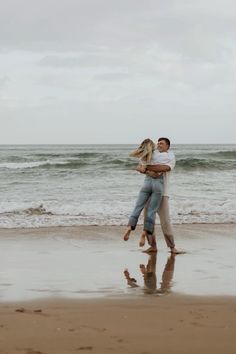 a man and woman hugging on the beach