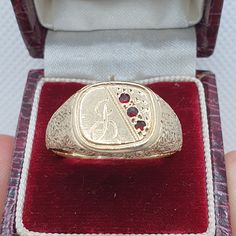 A vintage 9ct gold signet ring with nicely decorated shoulders and 3 ruby paste stones on the face. The face also has a letter engraving which looks like an "F" but could be "L".   Weight: 5.25 g. Size: UK V.5 or 11. Hallmarked "F" for 1980. Condition: Good used vintage with surface scratches commensurate with age. *Ring box for display only Please check out the other items in my shop. Be sure to view all photos and videos for condition and read the titles and descriptions. Sizes are in the latt Signet Rings, Gold Signet Ring, A Letter, Vintage Jewellery, Ring Box, Signet Ring, Favorite Things Gift, Precious Metals, The Face