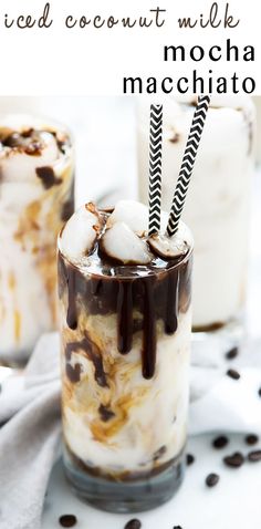 two glasses filled with ice cream, chocolate and marshmallows on a table