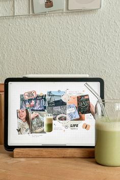 a glass of green juice next to a tablet