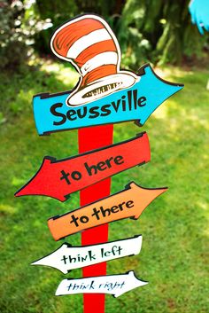 the cat in the hat is on top of a pole with signs that read seussville to here, think left and think right