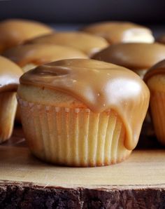 cupcakes with frosting sitting on top of a wooden table