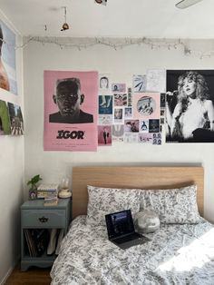 a bedroom with posters on the wall and a bed in it's centerpiece