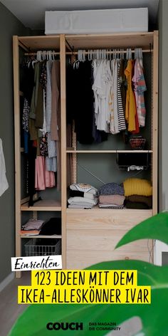 an open closet with clothes hanging on the rack and a plant in front of it