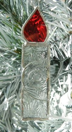 a glass ornament hanging from a christmas tree