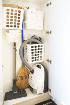 a white closet filled with different types of cleaning equipment