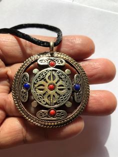 This beautiful double Vajra and Tibetan script Om pendant is made in Nepal. it is very unique and beautifully handcrafted pendant. Om symbolizes purification of body, mind and spirit. Doubles Vajra is indescribable. combination of two powerful and sacred symbol mandala pendant is ready to wear. it is made out of bronze and have coral, lapis and turquoise on it symbolizes wealth health. coral is for wealth and turquoise and lapis are for health. size of the pendant is 1.8 inches diameter. Spiritual Medallion Jewelry, Spiritual Jewelry With Large Pendant, Handmade Jewelry For Blessings And Festivals, Symbolic Handmade Jewelry For Meditation, Handmade Jewelry For Blessing And Festivals, Handmade Symbolic Jewelry For Meditation, Traditional Handmade Jewelry For Blessings, Spiritual Round Pendant Jewelry For Festival, Spiritual Large Pendant Jewelry For Festival