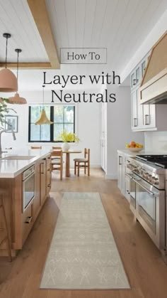 a kitchen with wooden floors and white walls, along with an area rug that says how to layer with neutrals