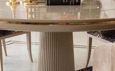 a table with two books on it and some chairs in front of it, along with a pair of leopard print slippers