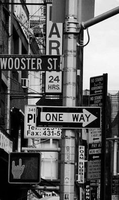 black and white photograph of street signs in new york city