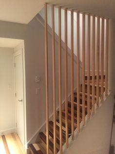 an empty room with wooden stairs and hard wood flooring