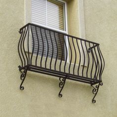 an iron balcony railing on the side of a building with shutters and latticed windows