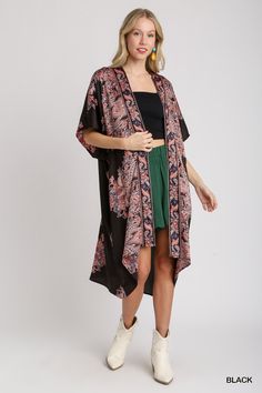 The Satin Breeze Border Print Kimono is an elegant and lightweight layering piece that adds a touch of sophistication to any outfit. Crafted from 100% polyester, this kimono features a smooth, silky satin finish that drapes beautifully over the body. The open front design allows for effortless styling, while the intricate border print adds a touch of artistry and visual interest. Short sleeves make it perfect for warmer weather, and the flowy silhouette enhances its relaxed, bohemian vibe. Fit & Bohemian Black Printed Kimono, Black Wrap Kimono For Spring, Elegant Beach Satin Kimono, Elegant Satin Beach Kimono, Black Floral Print Kimono For Summer, Summer Black Floral Print Kimono, Black Bohemian Kimono With Floral Print, Black Flowy Kimono With Kimono Sleeves, Black Summer Kimono With Kimono Sleeves