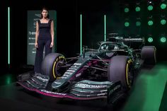 a woman standing next to a racing car on display