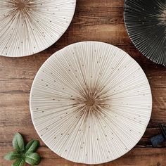 three white plates sitting on top of a wooden table