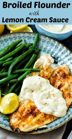 grilled chicken breast with lemon cream sauce on a blue plate next to green beans