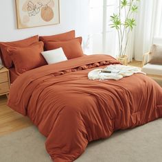 a bed with an orange comforter and pillows