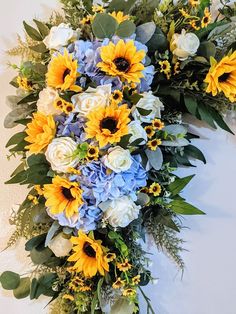 a bouquet of sunflowers, roses and blue hydrangeas on a wall