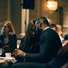 a man and woman sitting next to each other at a table