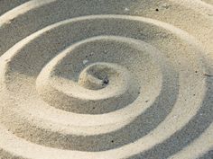 an image of a spiral design in the sand