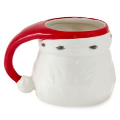 a white and red coffee mug with black dots on the bottom, in front of a white background