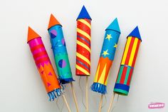 colorful paper rockets are lined up on sticks