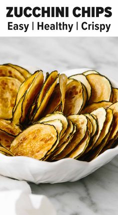 zucchini chips in a white bowl on a marble countertop with text overlay