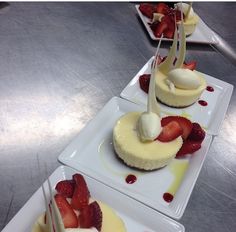 three desserts with strawberries and cream on them are lined up on white plates