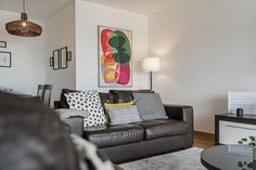 a living room filled with furniture and a painting on the wall above it's coffee table