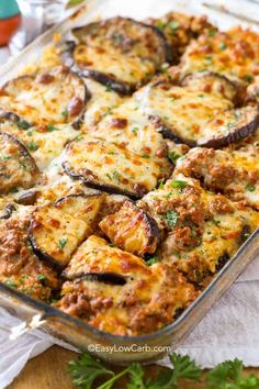 a casserole dish filled with meat and cheese, garnished with parsley