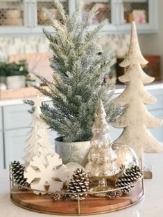 small christmas trees sitting on top of a wooden tray next to a kitchen countertop